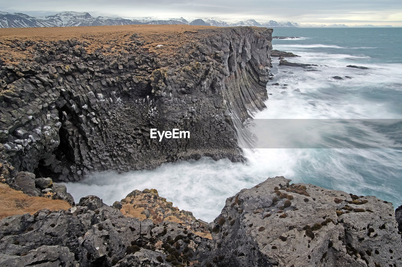 Scenic view of rocks in sea against sky