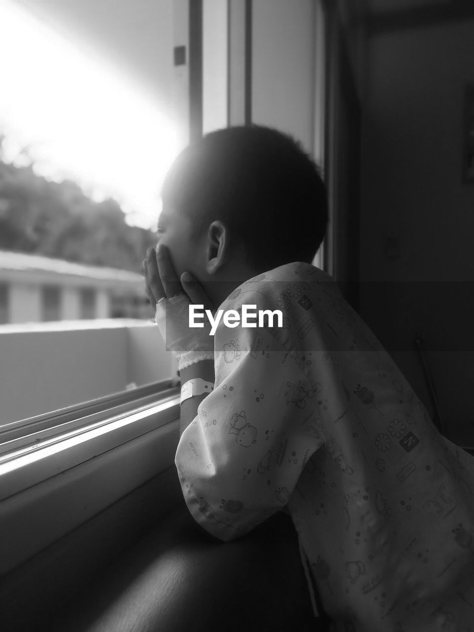 PORTRAIT OF BOY LOOKING THROUGH WINDOW AT BUS