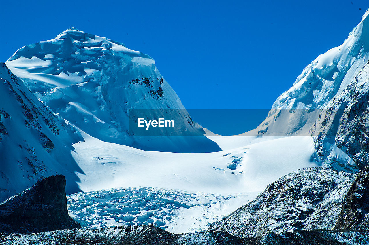 SCENIC VIEW OF SNOWCAPPED MOUNTAIN AGAINST BLUE SKY