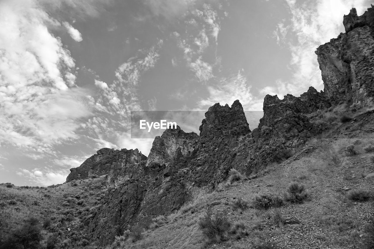 Low angle view of rocky mountains against sky