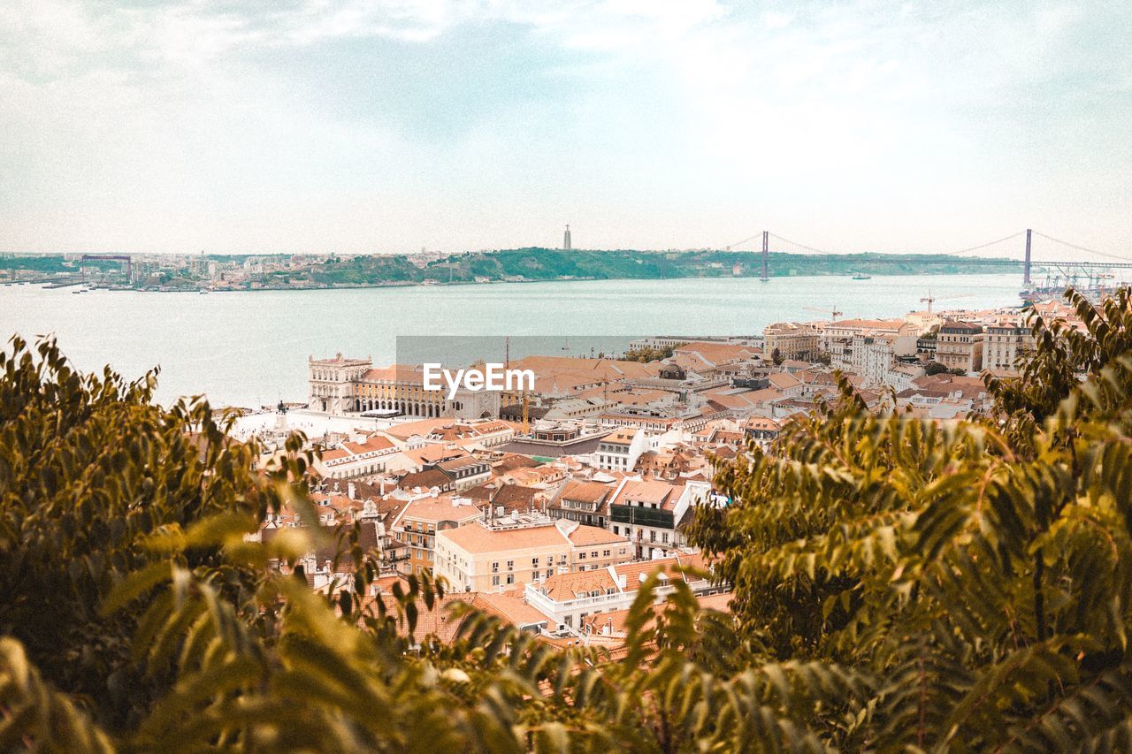 High angle view of townscape by sea against sky