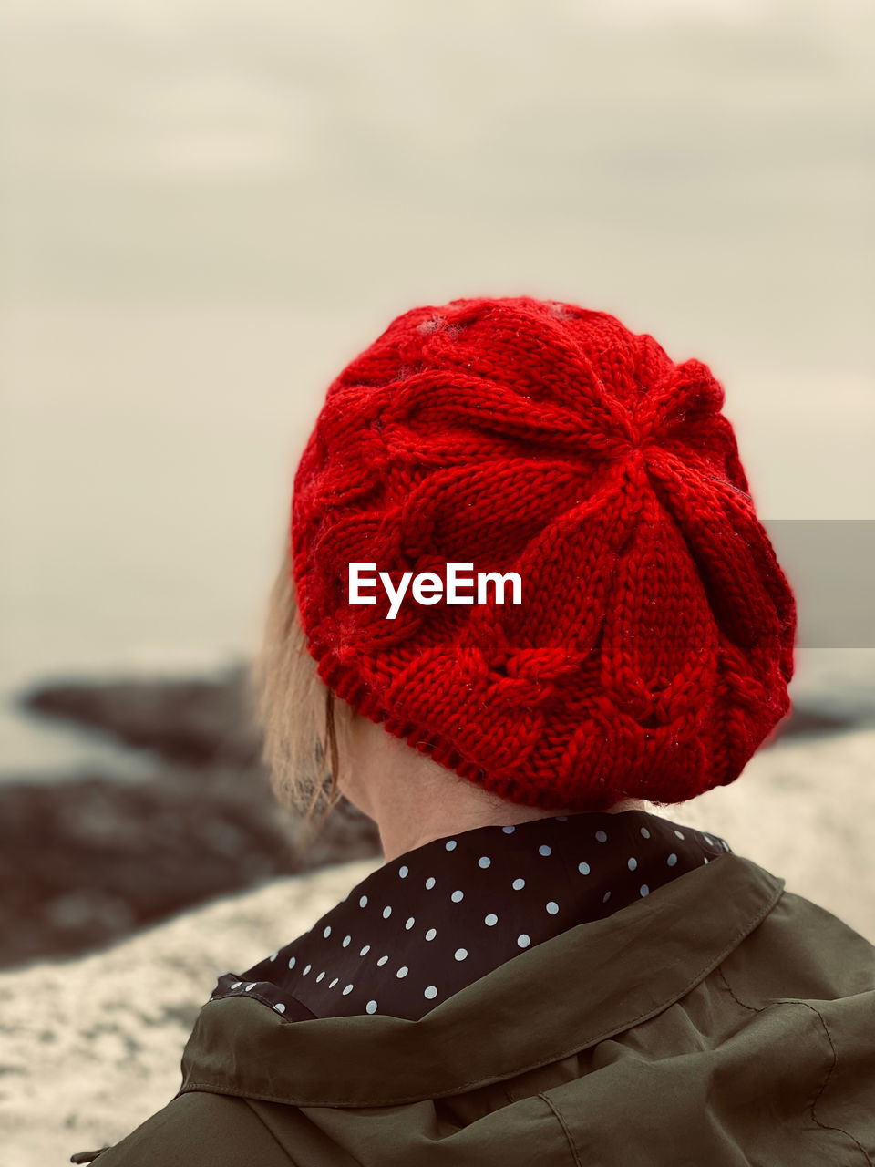 Rear view of a woman wearing a red knit hat in winter