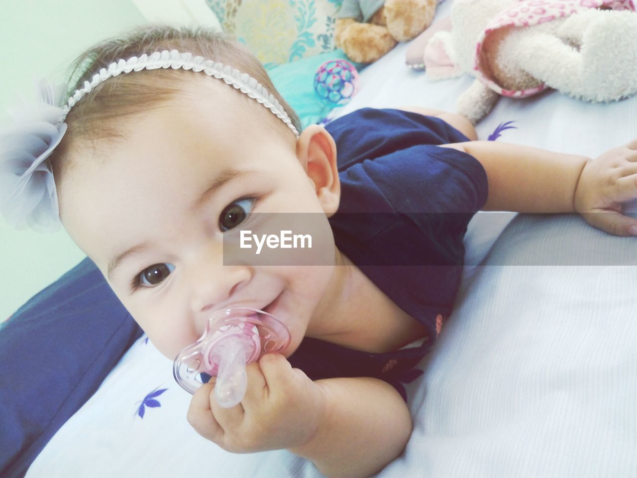 Close-up of cute baby girl holding pacifier