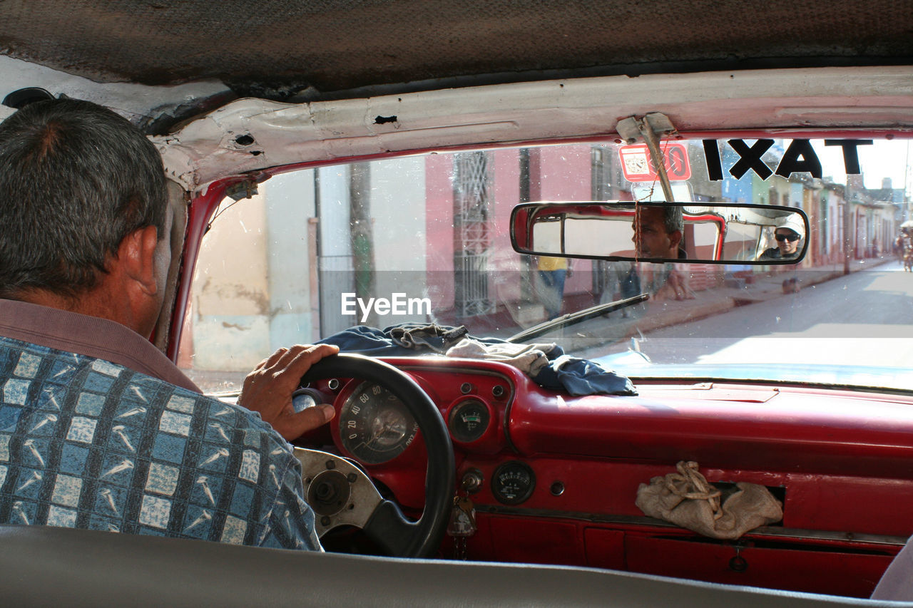 REAR VIEW OF A PERSON SITTING IN CAR