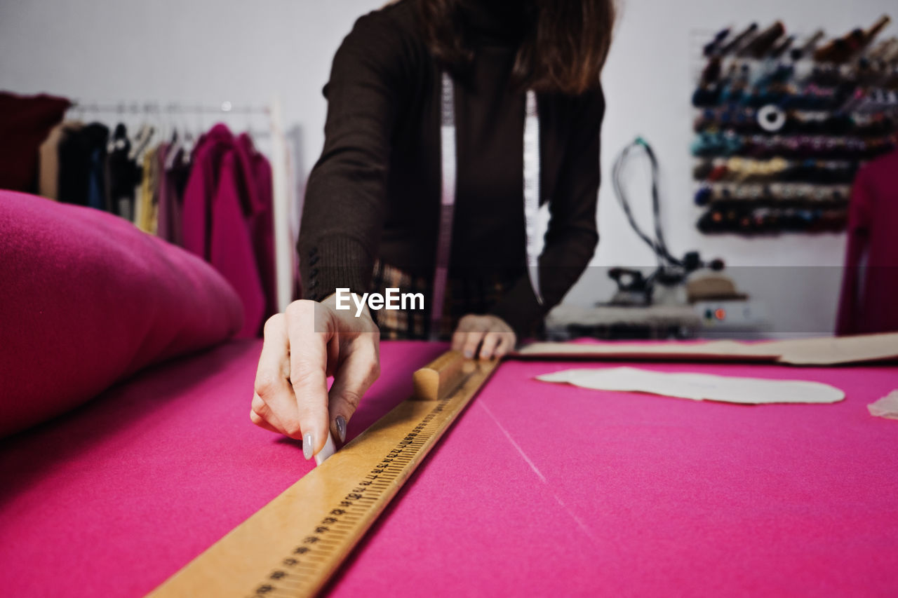 Sewing sustainable fashion industry. seamstress working with clothing and sewing pattern on table