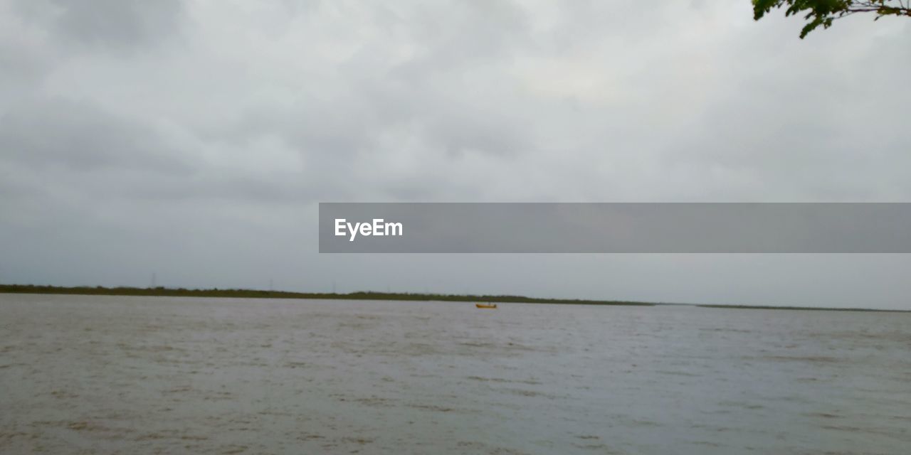 SCENIC VIEW OF BEACH AGAINST CLOUDY SKY