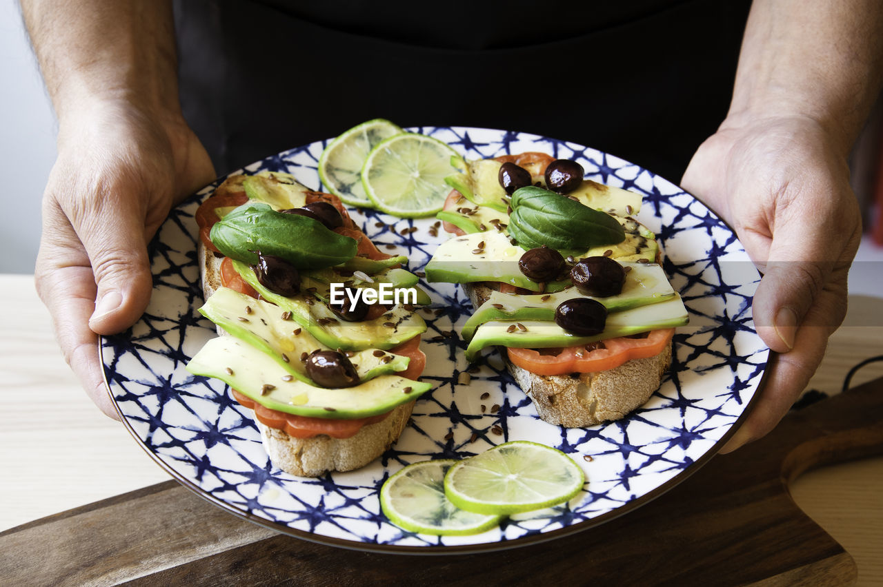 Midsection of man holding food in plate on table