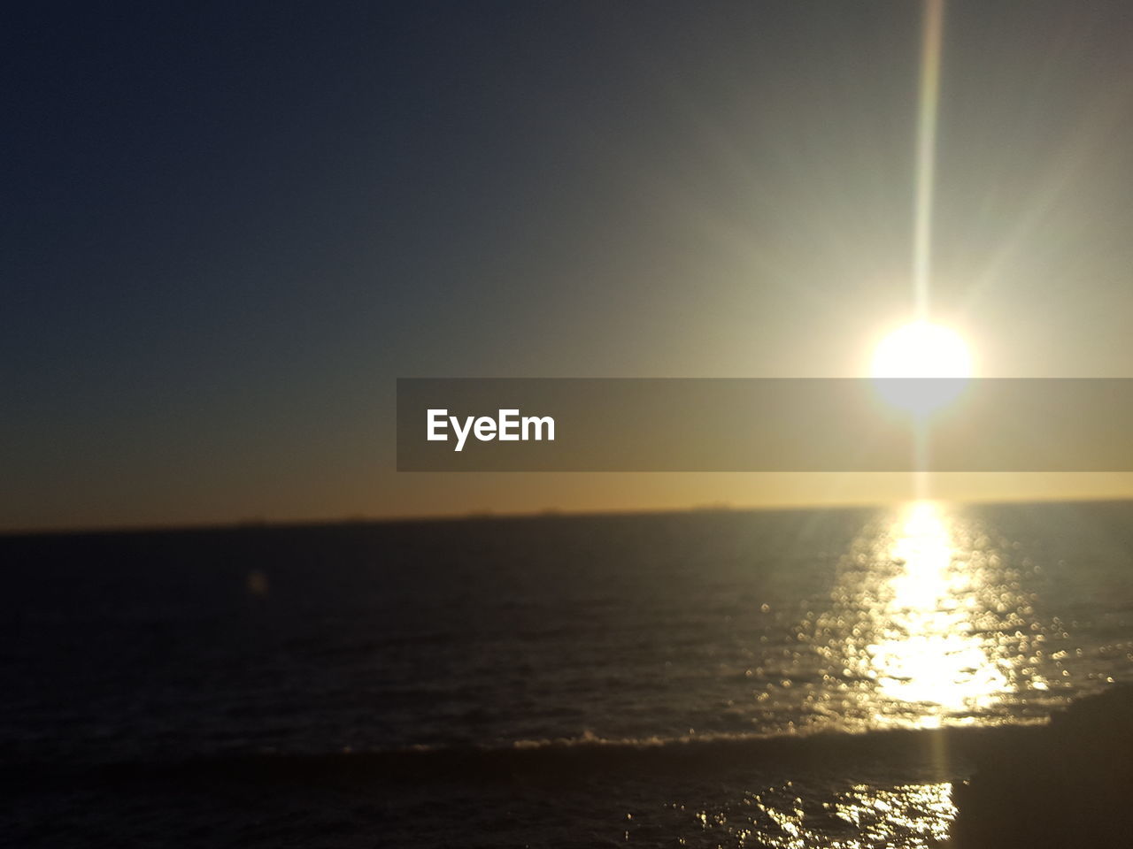 SCENIC VIEW OF BEACH AGAINST SKY AT SUNSET