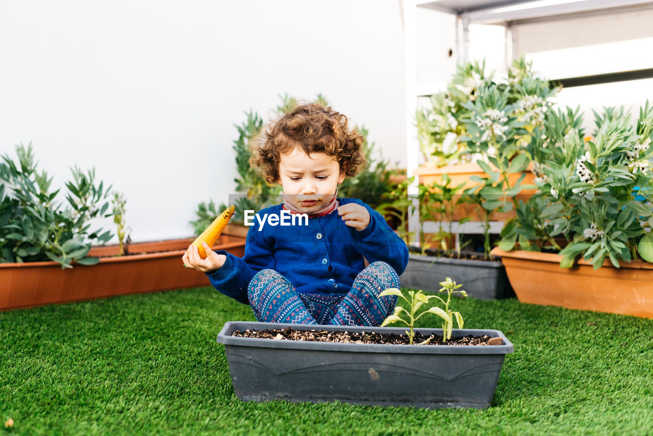 BOY SITTING IN BACKYARD