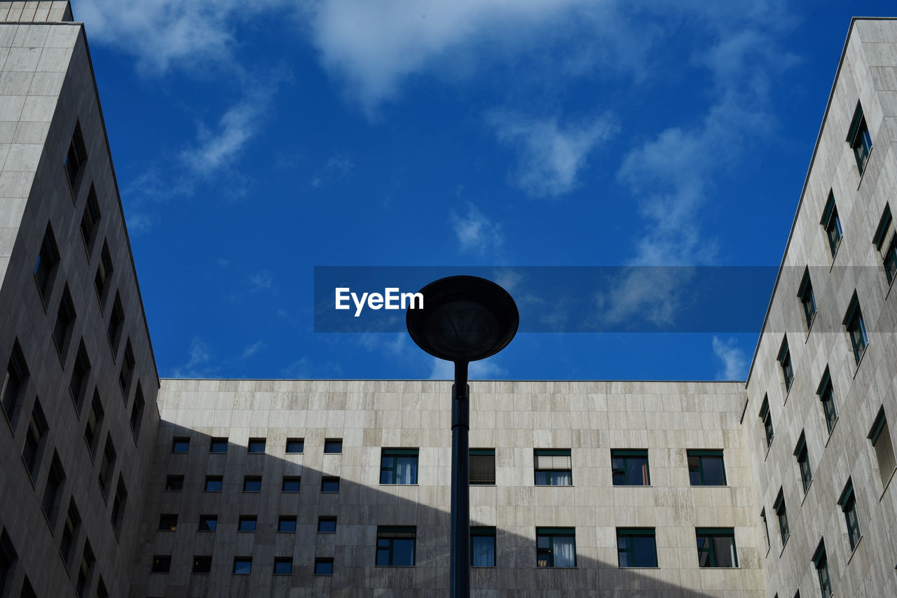 LOW ANGLE VIEW OF BUILDINGS AGAINST CLOUDY SKY