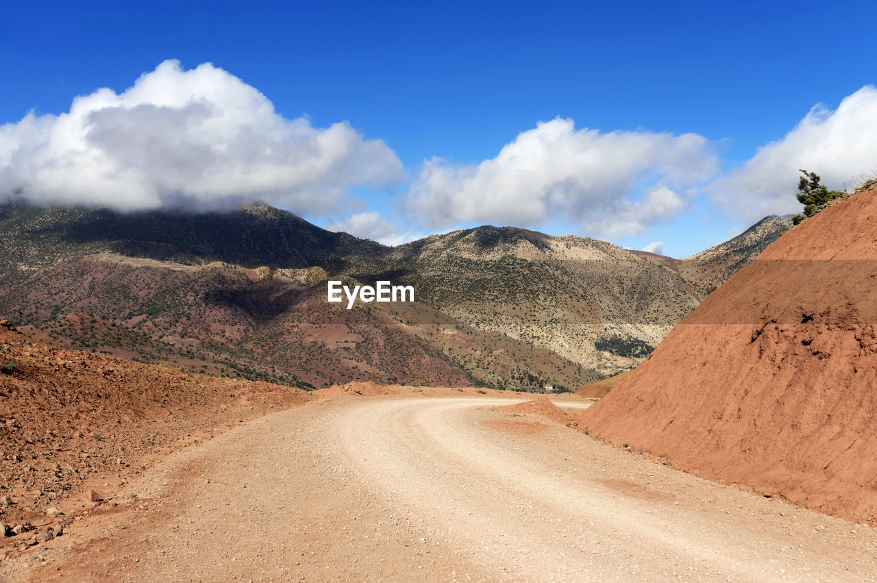 SCENIC VIEW OF ROAD AMIDST MOUNTAINS AGAINST SKY