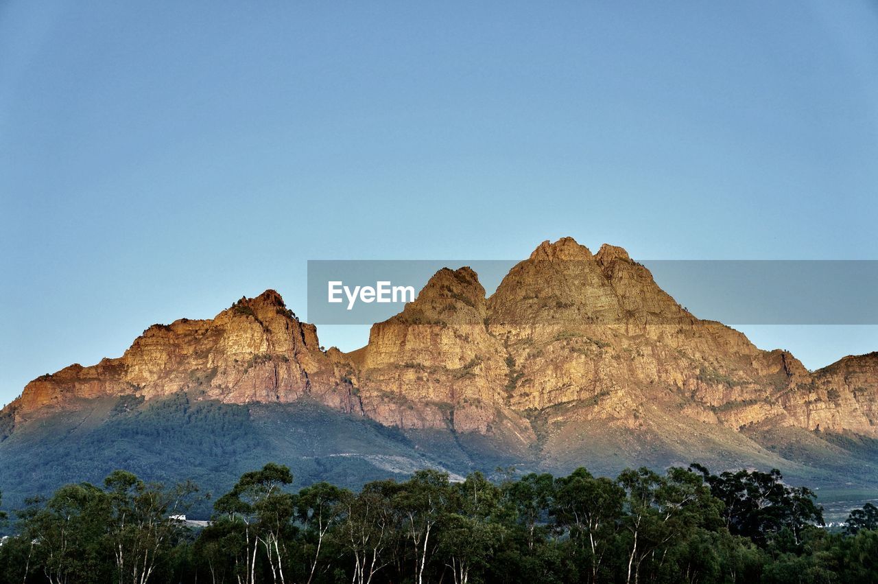 Rock formations against clear blue sky