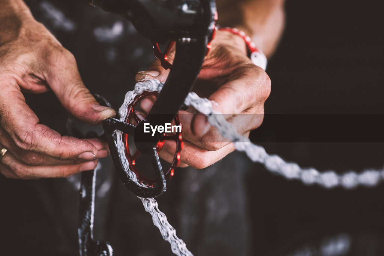 Close-up of mechanic repairing bicycle chain at workshop