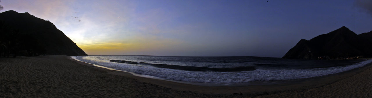 PANORAMIC VIEW OF CALM BEACH AGAINST THE SKY