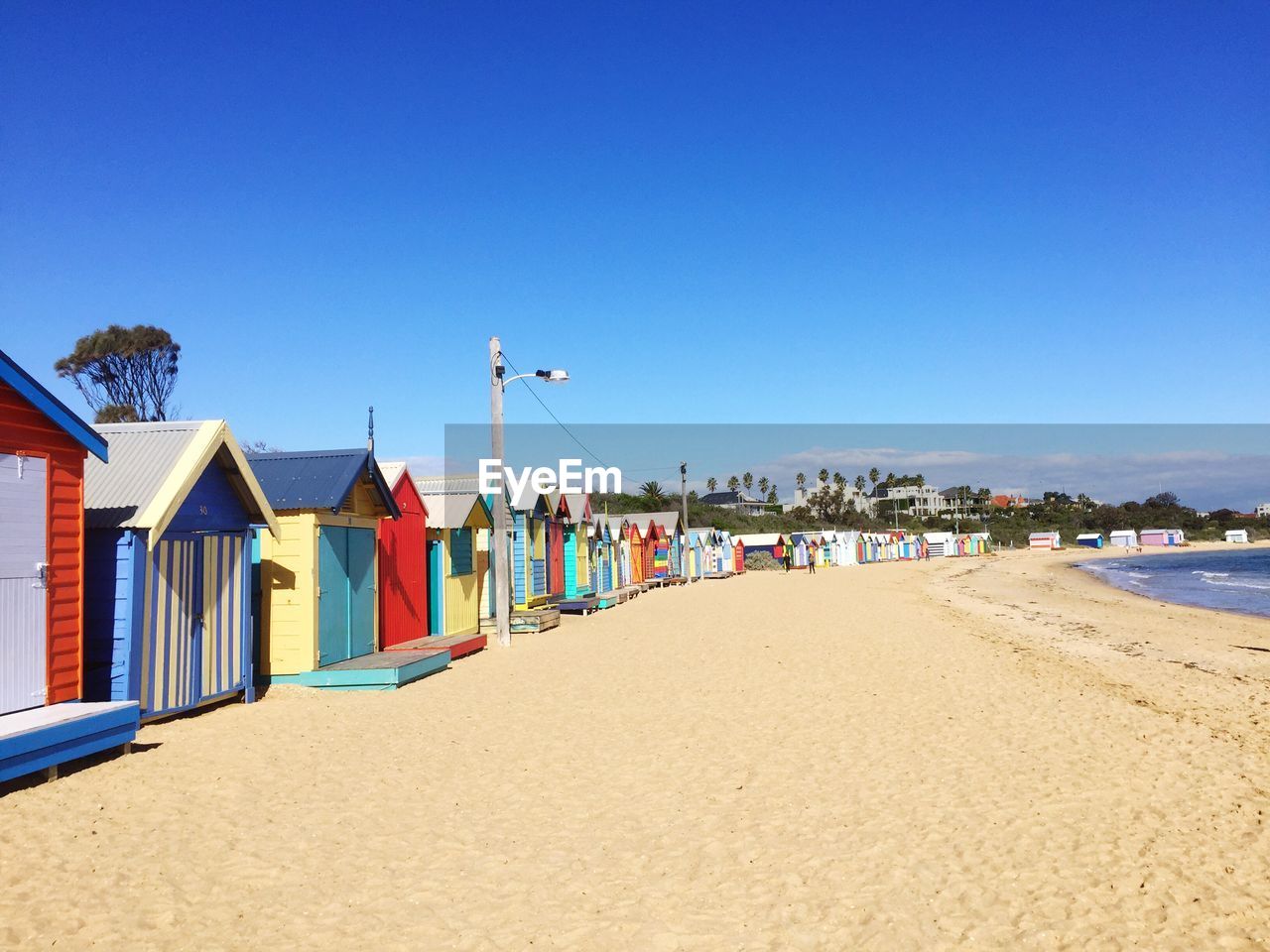 Colorful huts at beach against clear sky