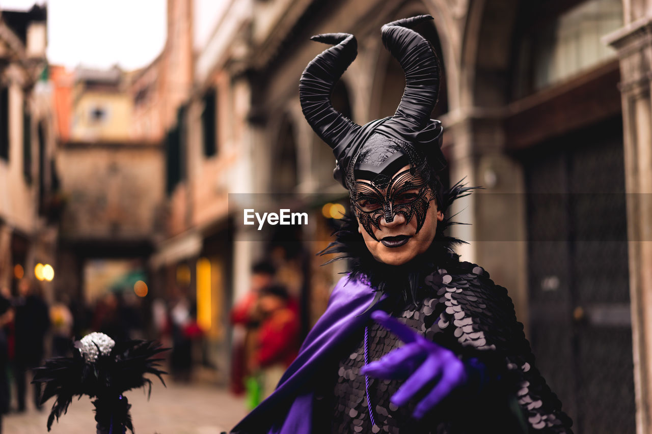 Portrait of man in devil costume at street during carnival