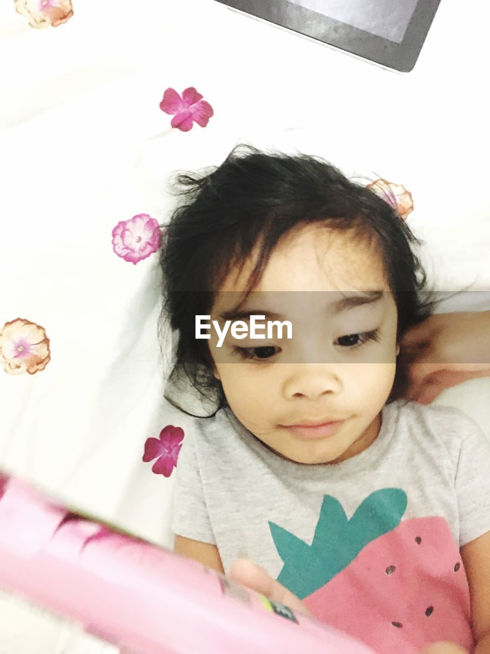 PORTRAIT OF CUTE GIRL LYING ON BED WITH PINK INDOORS