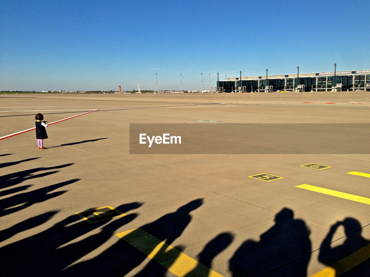 Shadow of people with girls standing on airport road
