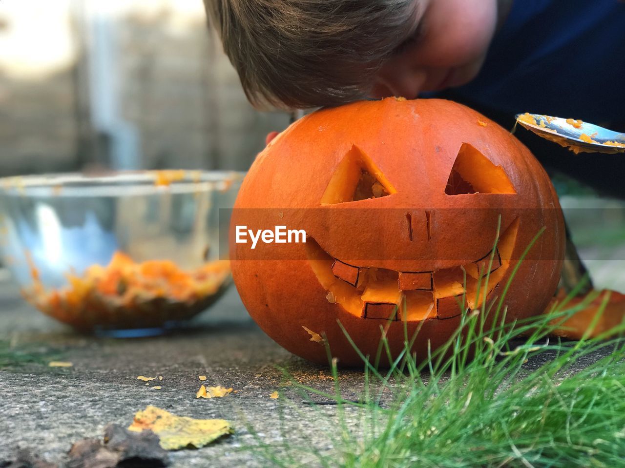 Close-up of boy peeking in jack o lantern