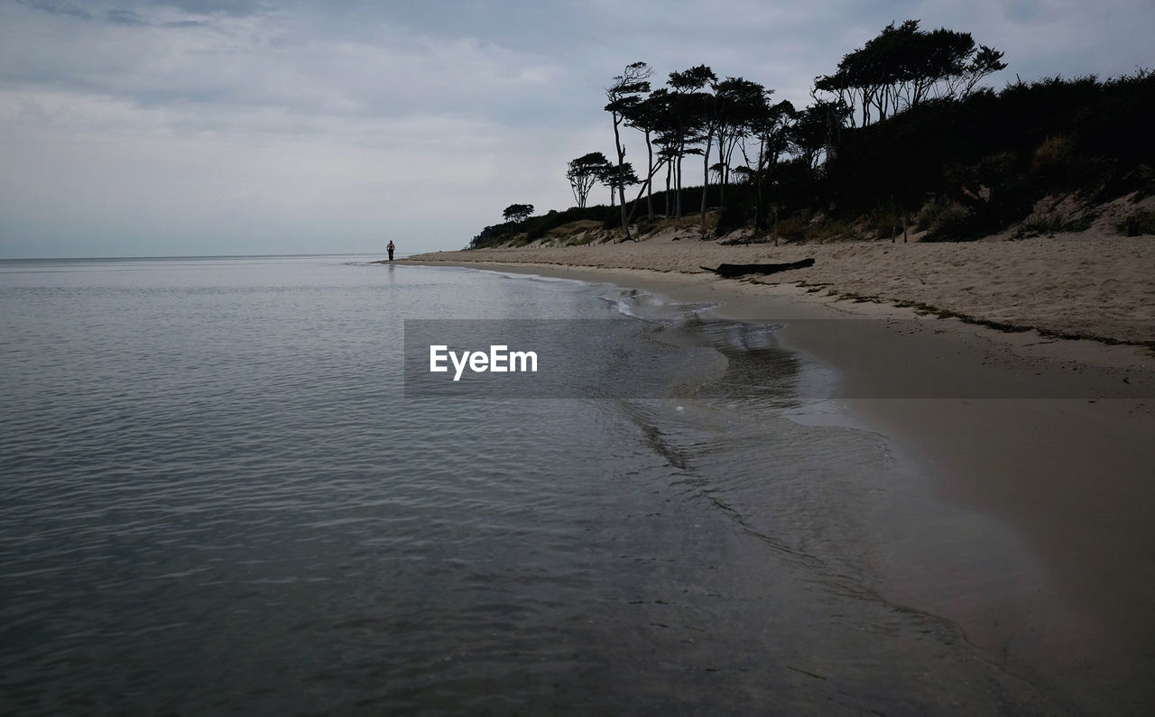 SCENIC VIEW OF BEACH AGAINST SKY AT SUNSET