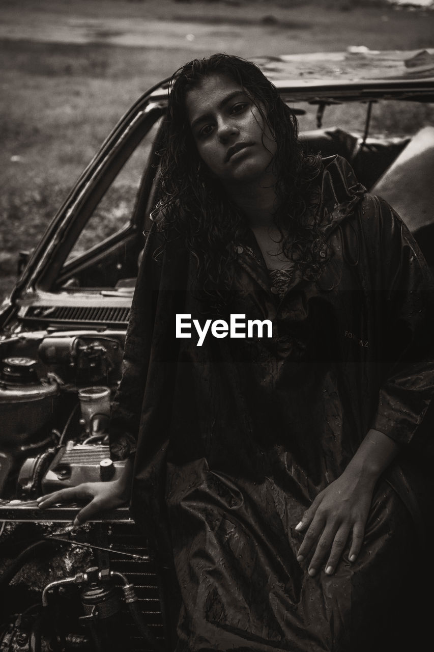 Portrait of woman grunge on broken car in rain