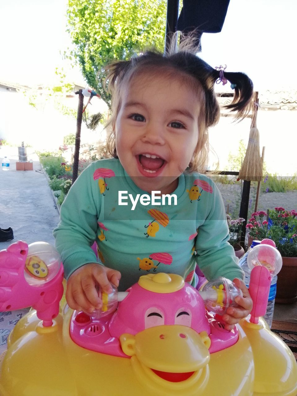 PORTRAIT OF A SMILING GIRL HOLDING BABY