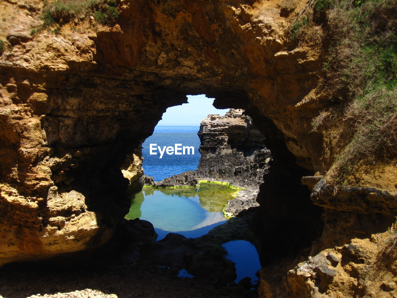 Rock formations in sea seen through cave