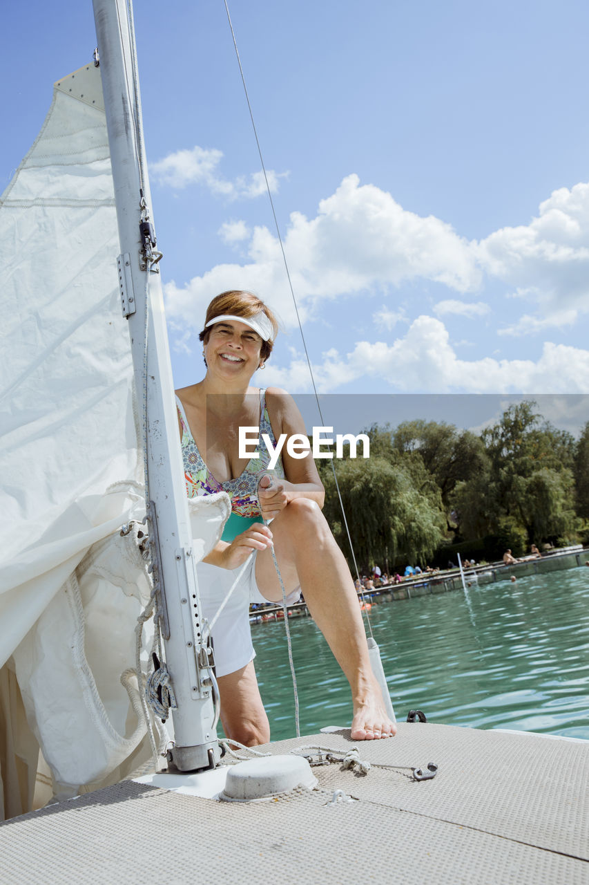 Happy senior woman enjoying vacation on sailboat