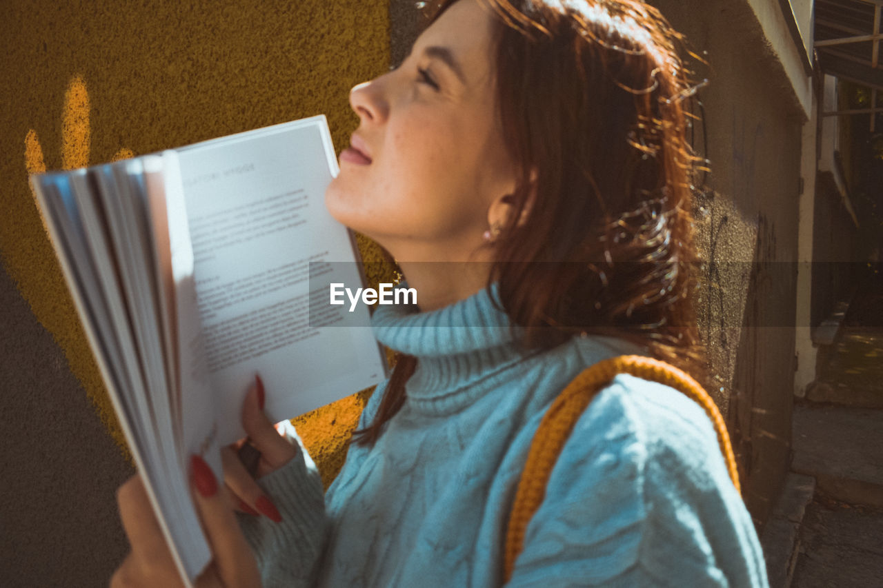 Midsection of woman reading book