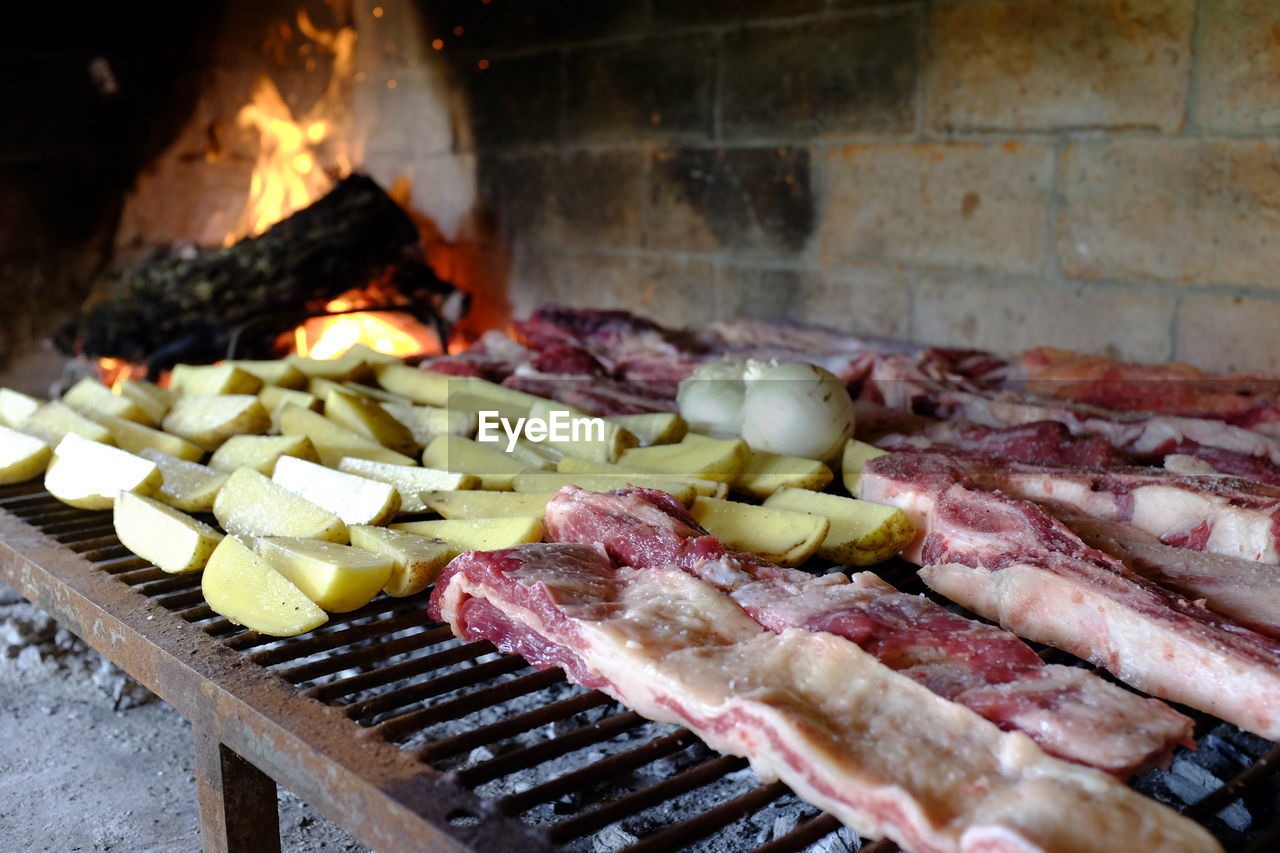 CLOSE-UP OF MEAT COOKING ON BARBECUE