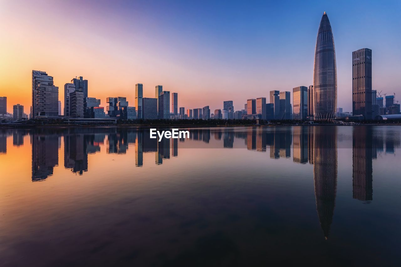 REFLECTION OF BUILDINGS IN CITY AGAINST SKY