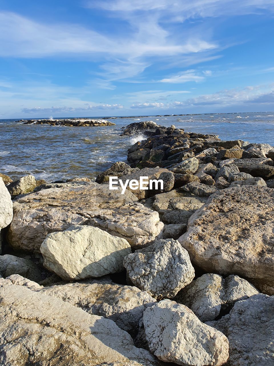 Scenic view of rocks on beach against sky