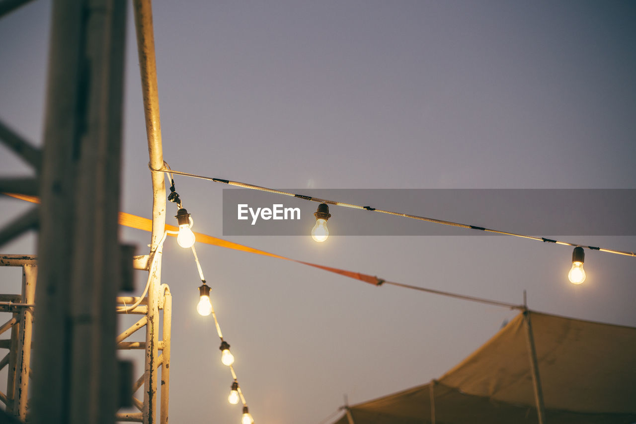 LOW ANGLE VIEW OF HANGING LIGHTS AGAINST SKY