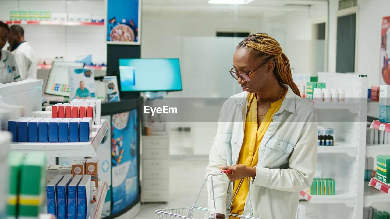 side view of young woman using mobile phone while standing at laboratory
