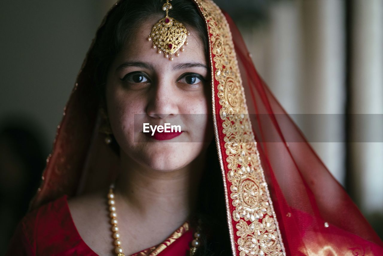 Close-up portrait of smiling young bride at home