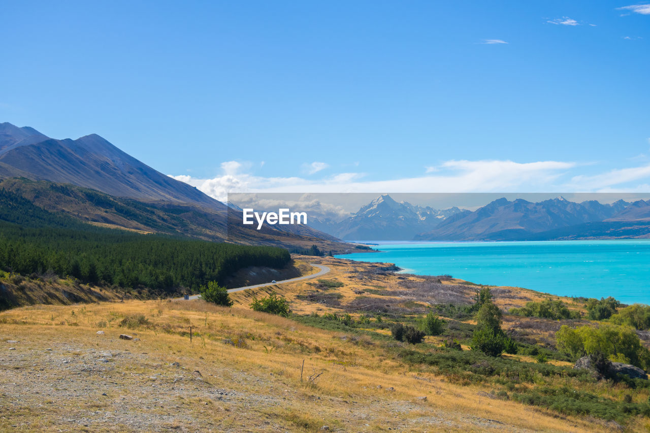 Scenic view of sea and mountains against blue sky