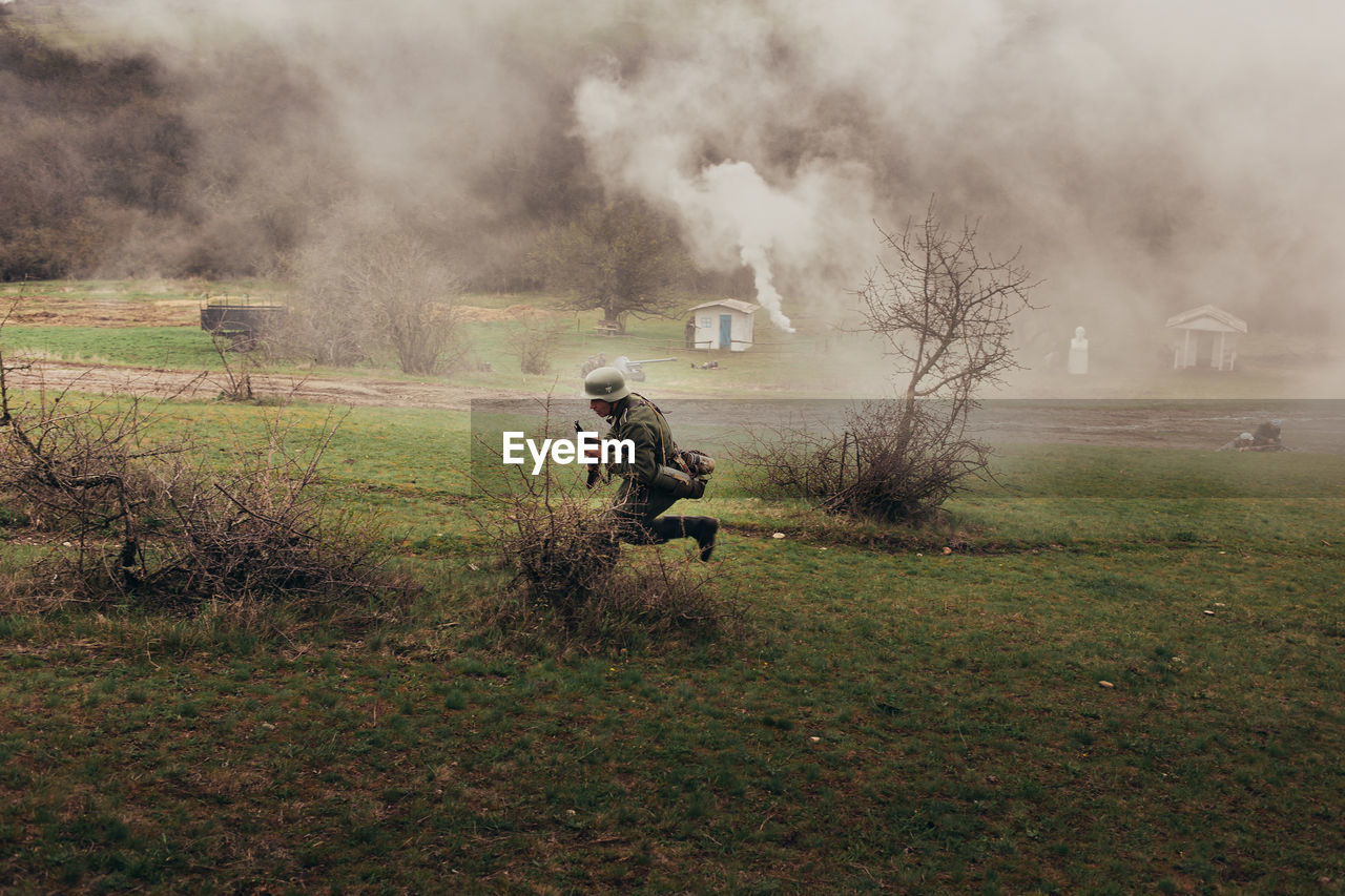 PEOPLE ON FIELD WITH TREES