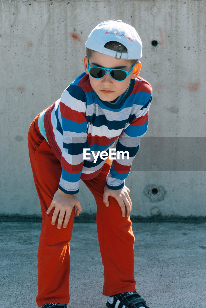 Portrait of boy standing against wall