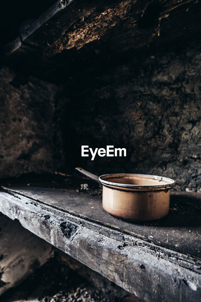 Abandoned lonesome copper pot left behind on an old wooden shelf in a lost place on corsica island.