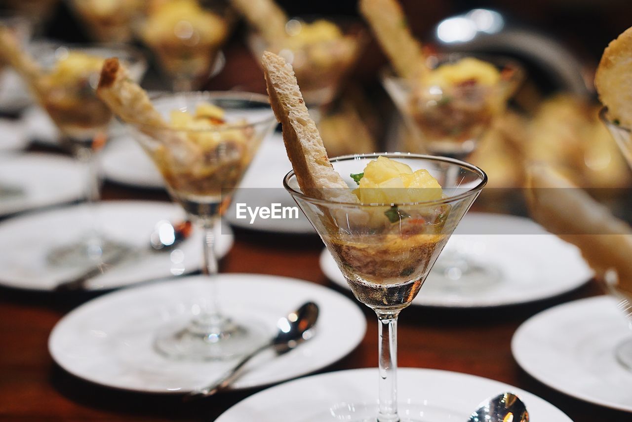 Close-up of food with bread served in martini glasses on table