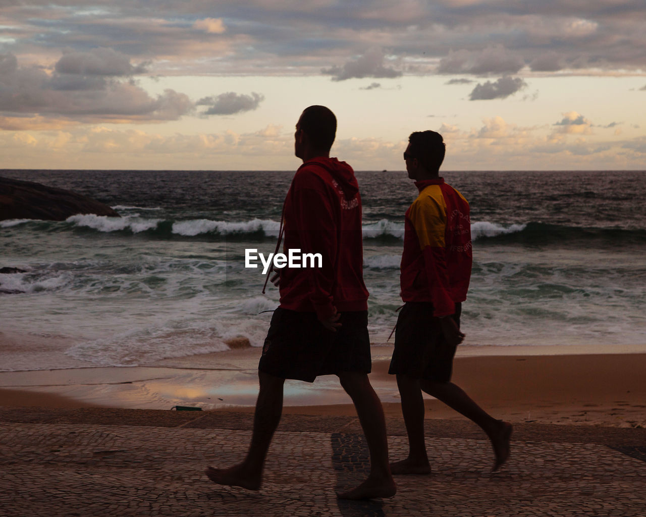 REAR VIEW OF MEN ON BEACH