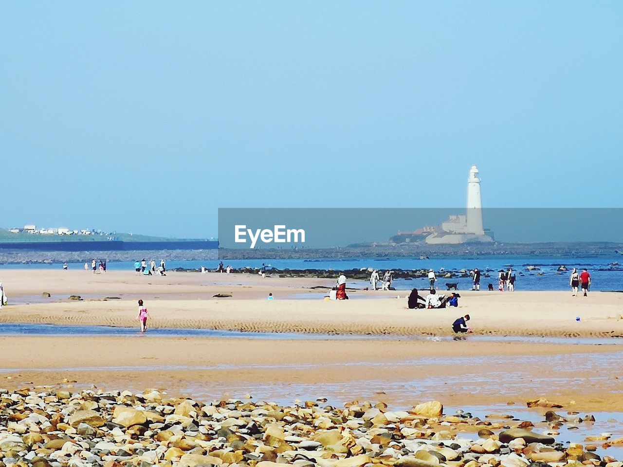 GROUP OF PEOPLE ON BEACH AGAINST SKY