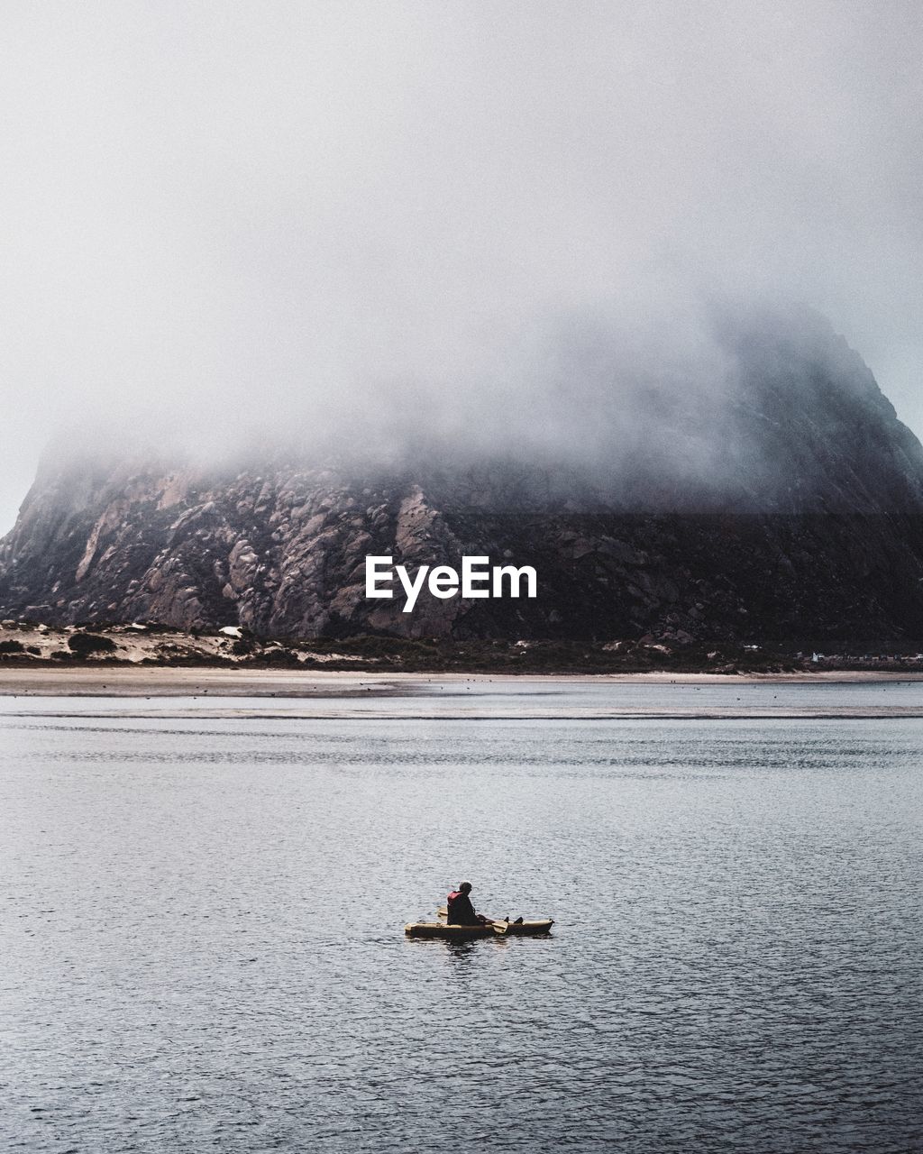 Man sailing on lake against sky