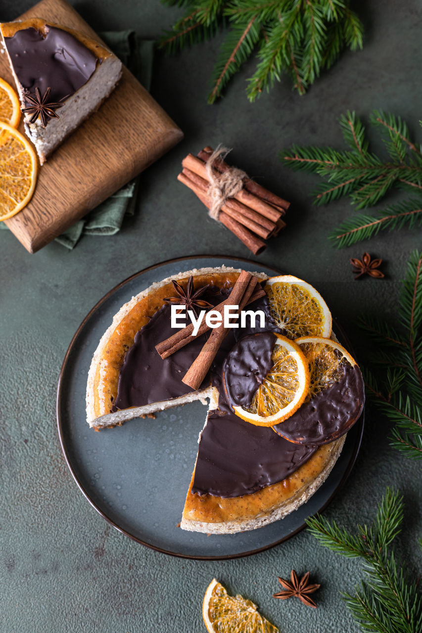 Cheesecake with chocolate decorated slices of dried oranges. festive christmas decoration.