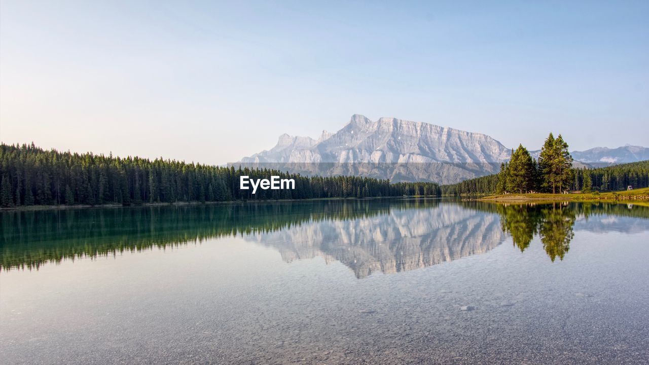 Scenic view of lake by mountains against sky