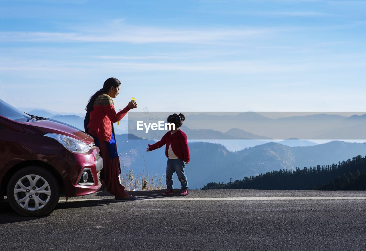 Mother and daughter on a road trip. car travel vacation concept photo against himalayan mountain.