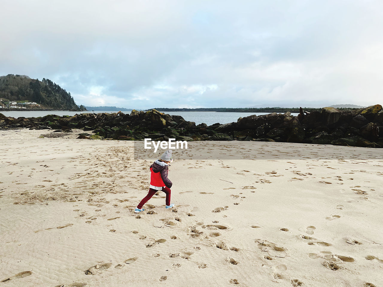 Rear view of girl on beach against sky