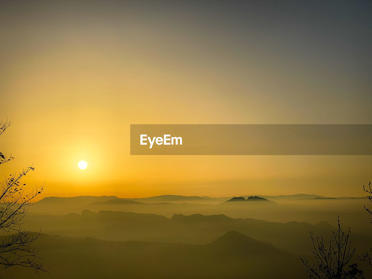 SCENIC VIEW OF SILHOUETTE MOUNTAINS AGAINST SKY AT SUNSET