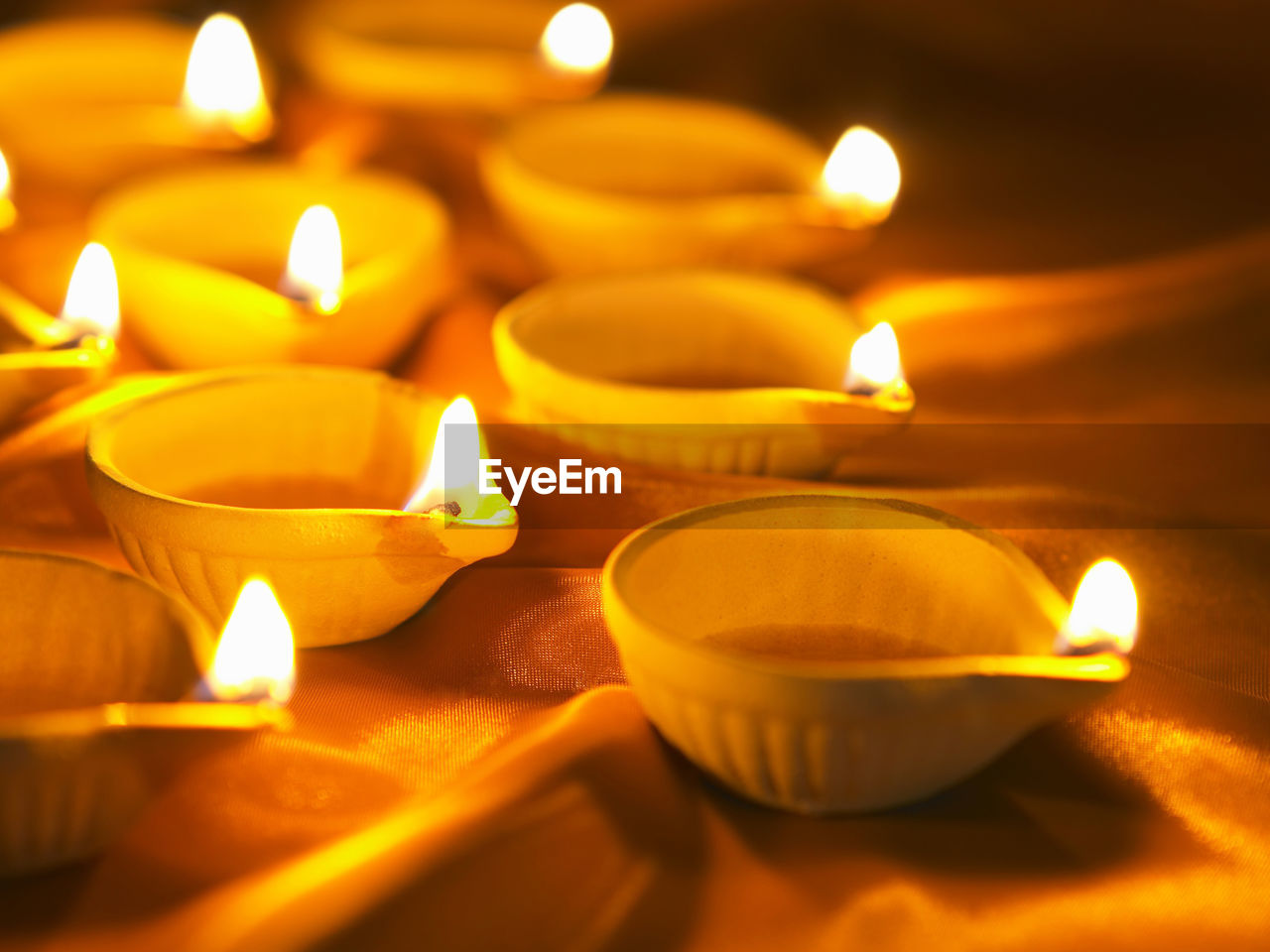 Close-up of lit diyas in darkroom