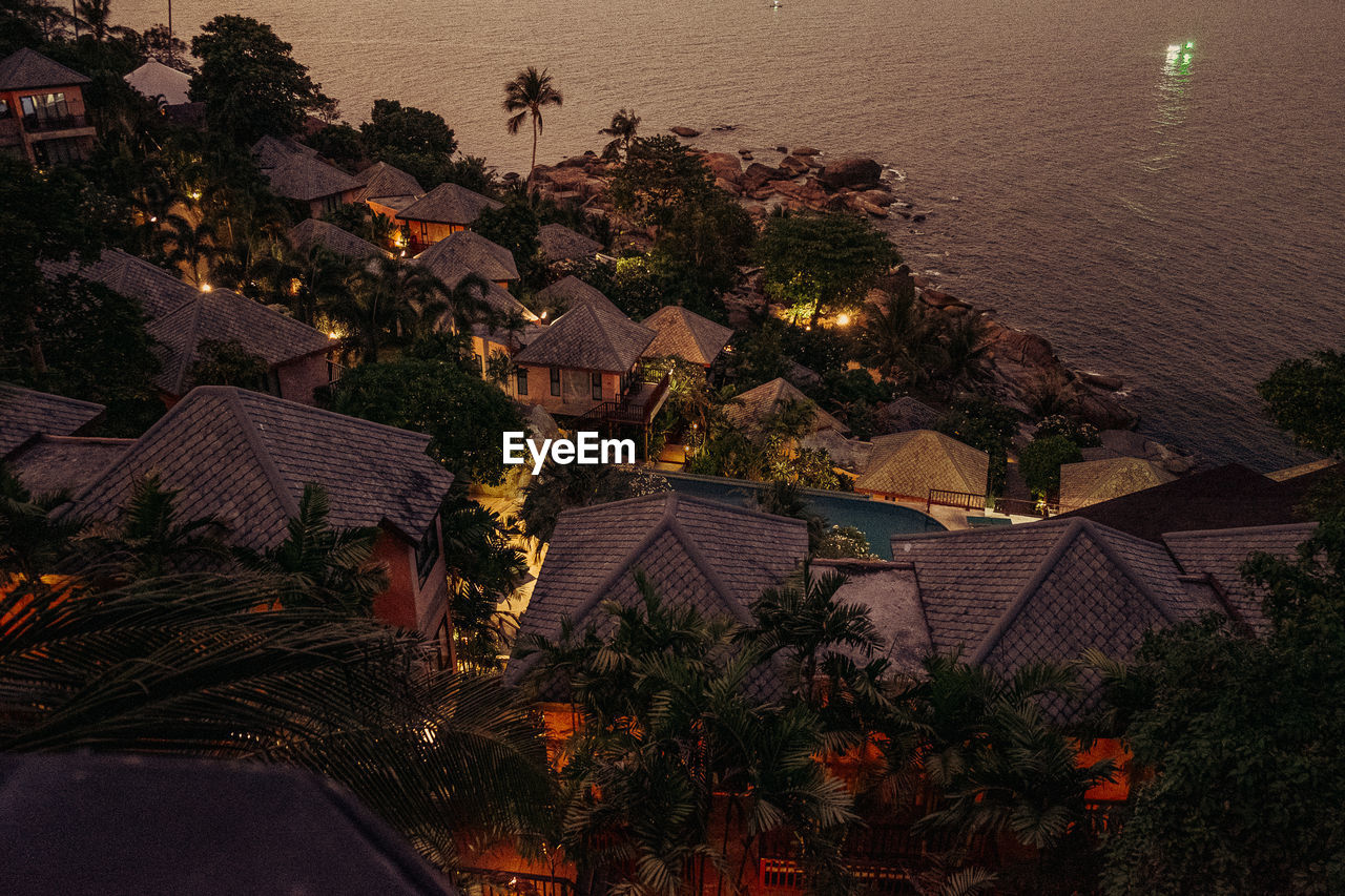 High angle view of houses by sea during sunset